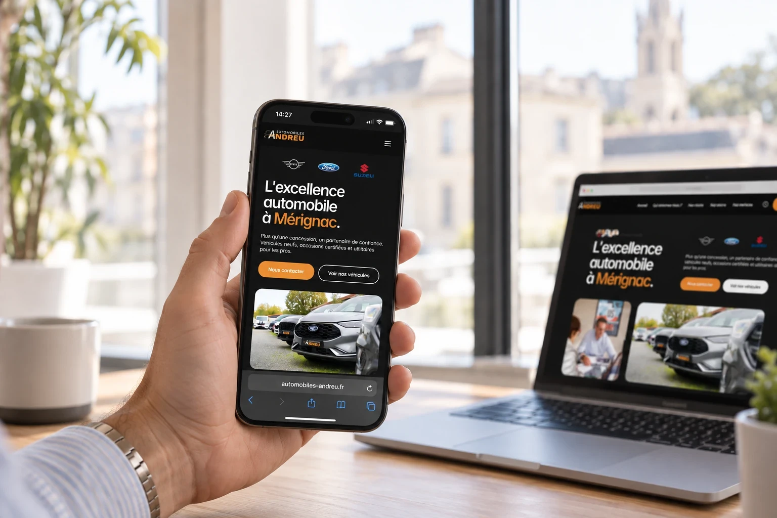 Version mobile du site Automobiles Andreu consultée sur iPhone, à côté d’un MacBook.