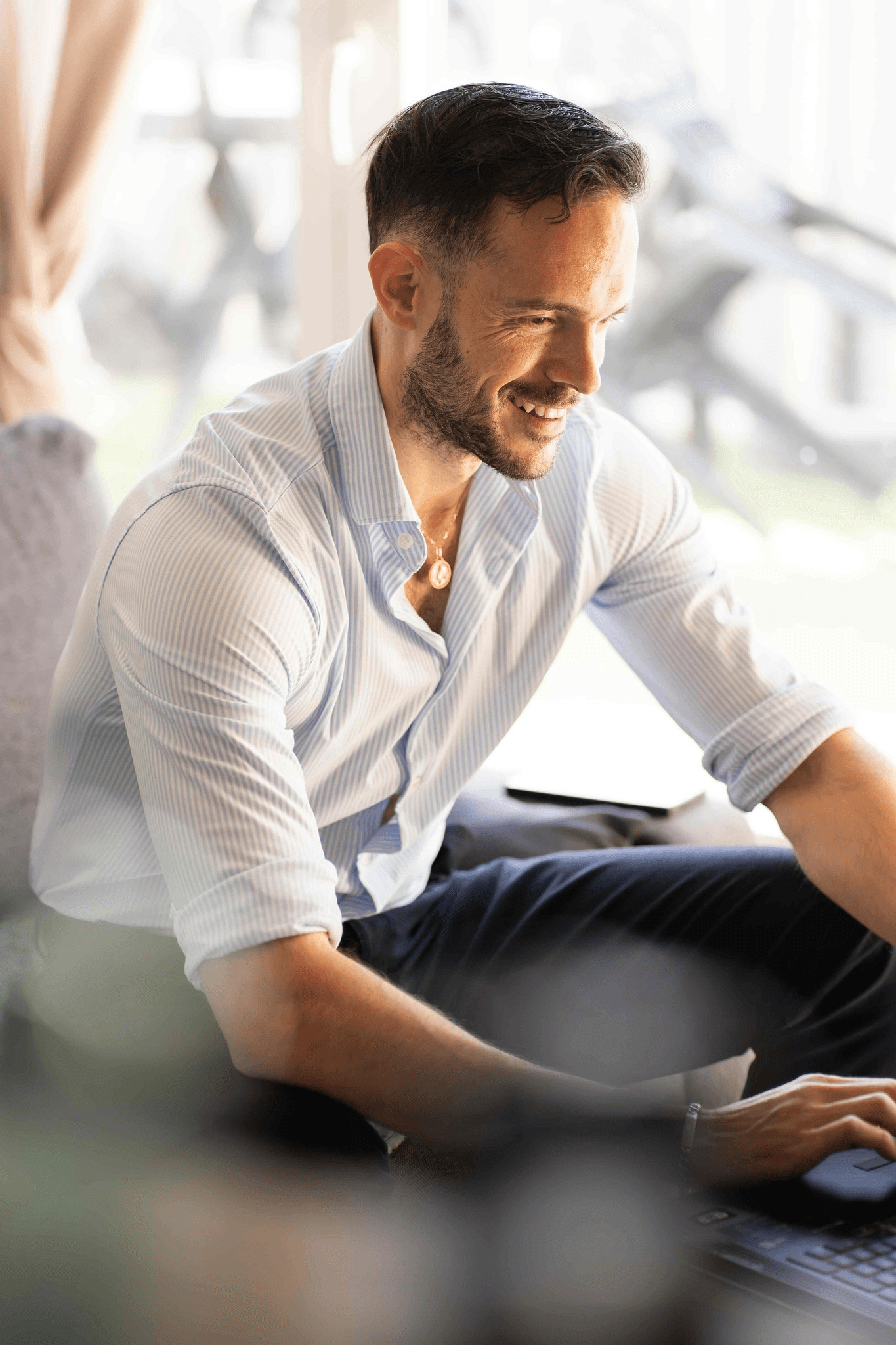 Homme souriant travaillant sur un ordinateur portable